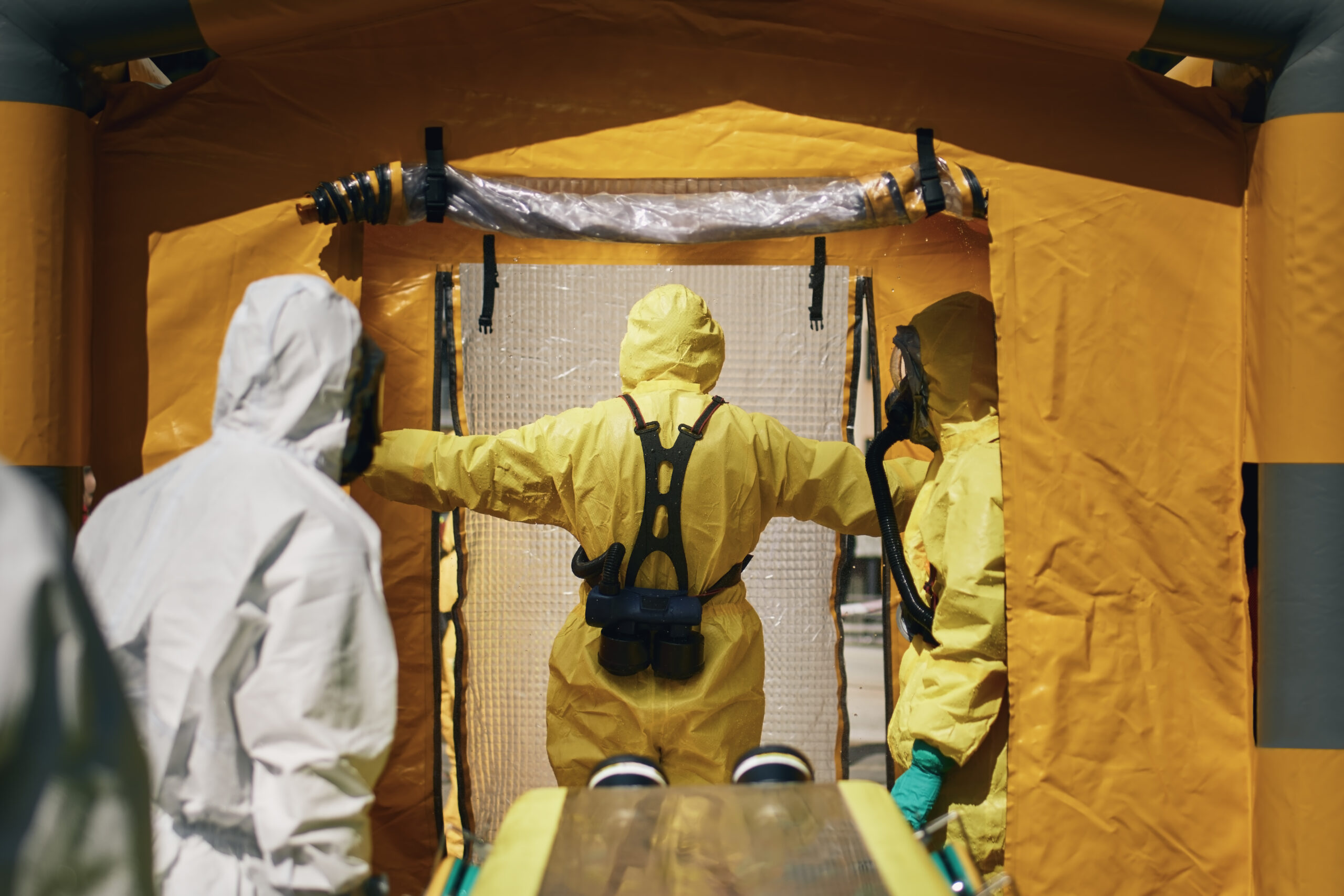 Members of biohazard teams of fire brigade and emergency medical service in protective suits.